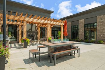 a patio with tables and benches in front of a building